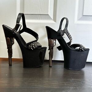 Pleaser size 6 7.5 inch black gun heels with bullet details, has visible wear